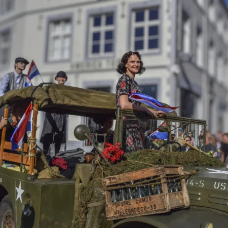 Recreación histórica de un desfile del Día de la Liberación, una experiencia de turismo cultural y viajes de historia para conocer la memoria y el patrimonio de la Segunda Guerra Mundial.
