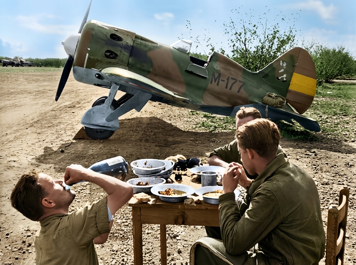 Pilotos republicanos disfrutando de una comida junto a un caza Polikarpov durante la Guerra Civil Española, imagen histórica de aviación militar, vida cotidiana en el frente y descanso de combatientes republicanos