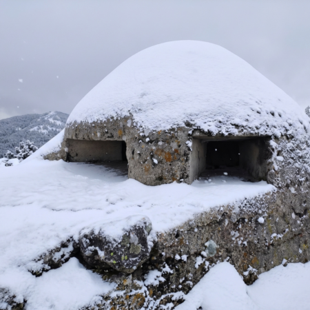 Búnker de la Guerra Civil Española en el Alto del León cubierto de nieve, un escenario histórico de la Sierra de Guadarrama para descubrir mediante viajes de historia, turismo cultural y experiencias en destinos de patrimonio y memoria de España.