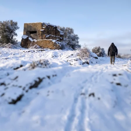 Paisaje del frente de la Sierra Norte cubierto de nieve, un escenario histórico para disfrutar de viajes de historia, turismo cultural y experiencias de patrimonio y memoria en España.