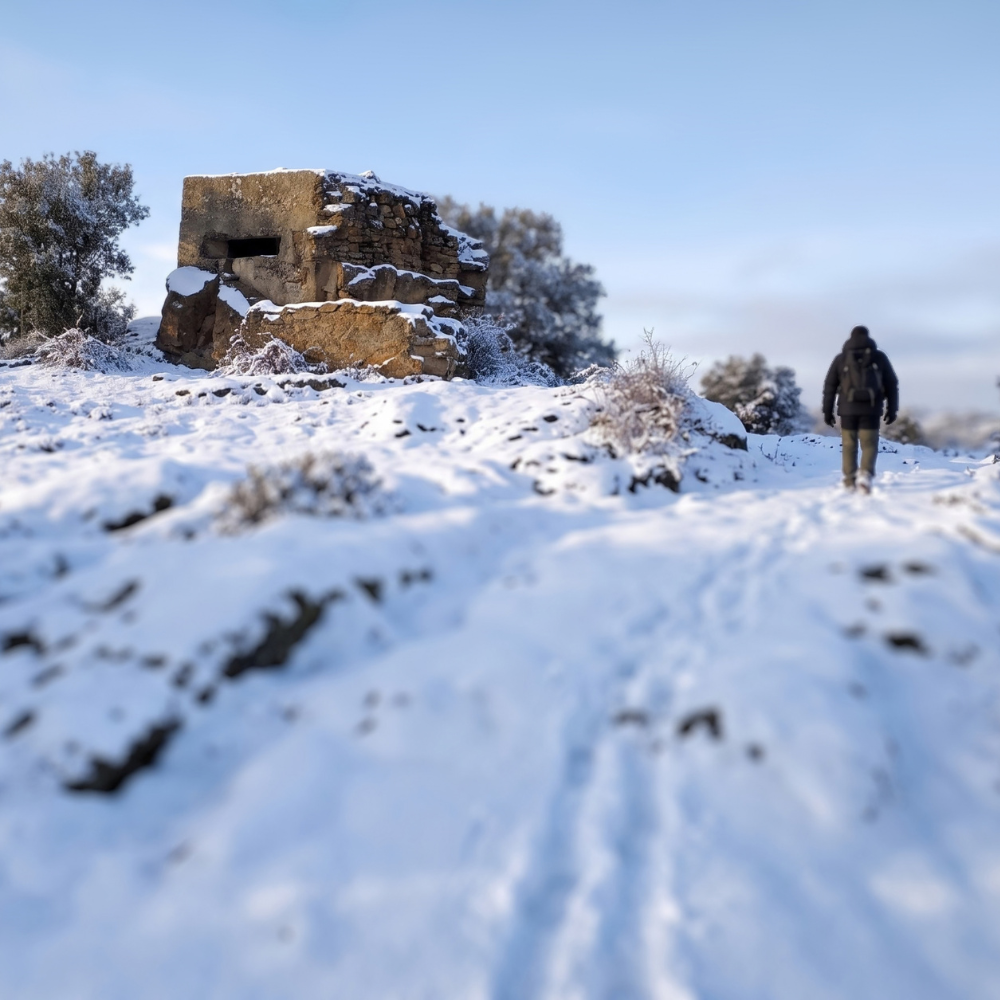 Paisaje del frente de la Sierra Norte cubierto de nieve, un escenario histórico para disfrutar de viajes de historia, turismo cultural y experiencias de patrimonio y memoria en España.