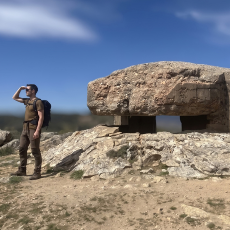 Excursionista junto a un búnker de la Guerra Civil Española en el Frente del Agua, una experiencia de turismo cultural y viajes de historia para descubrir el patrimonio y los escenarios históricos de España.